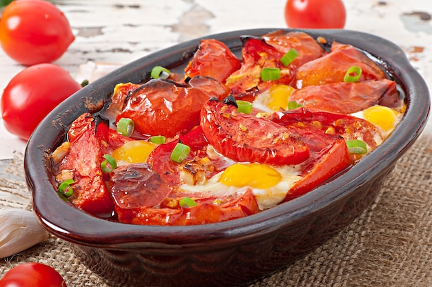 Tomates al horno con ajo y huevos decorados con cebolla verde