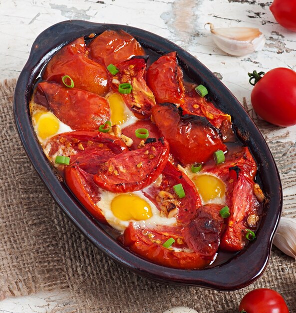 Tomates al horno con ajo y huevos decorados con cebolla verde