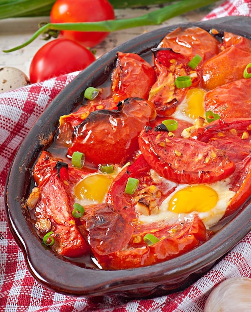 Tomates al horno con ajo y huevos decorados con cebolla verde