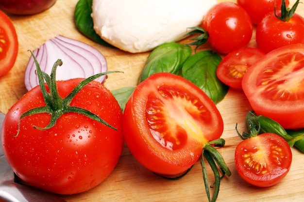 Tomates, albahaca y mozzarella sobre tabla de madera