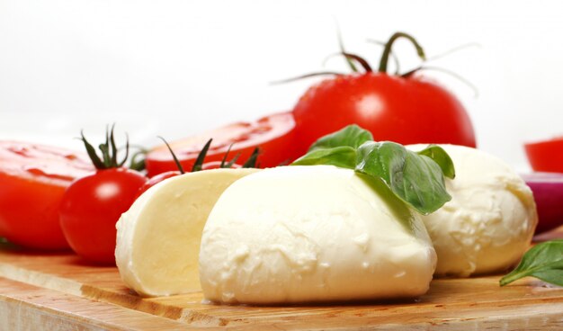 Tomates, albahaca y mozzarella sobre tabla de madera