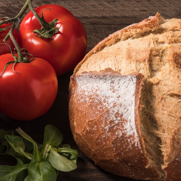 Foto gratuita tomates de alto ángulo y arreglo de pan