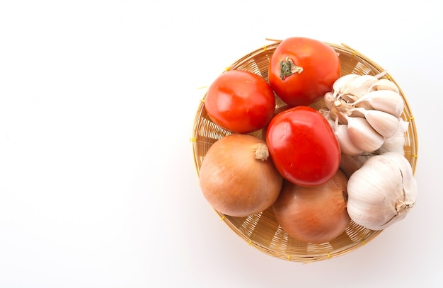Foto gratuita tomates, cebolla y ajo en la canasta