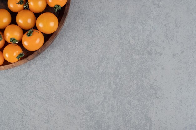 Tomates cherry amarillos aislados en una mesa de hormigón.