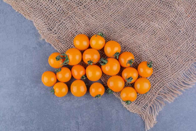 Tomates cherry amarillos aislados en superficie azul