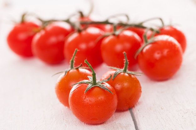 Tomates cherry frescos sobre una superficie blanca