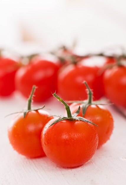 Tomates cherry frescos sobre una superficie blanca