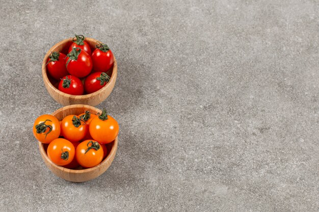 Tomates cherry orgánicos en dos tazones separados rojo y amarillo.