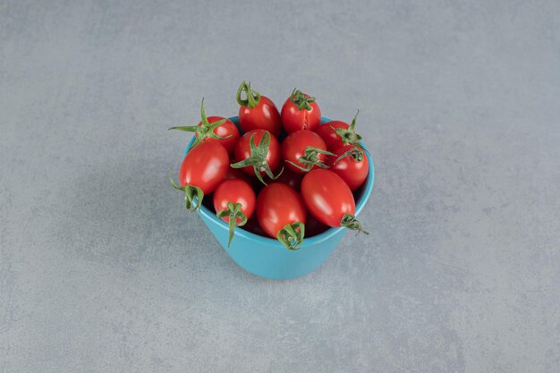 Foto gratuita tomates cherry rojos aislados en mesa de hormigón.