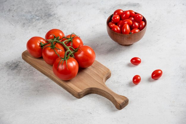 Tomates cherry rojos frescos en un cuenco de madera