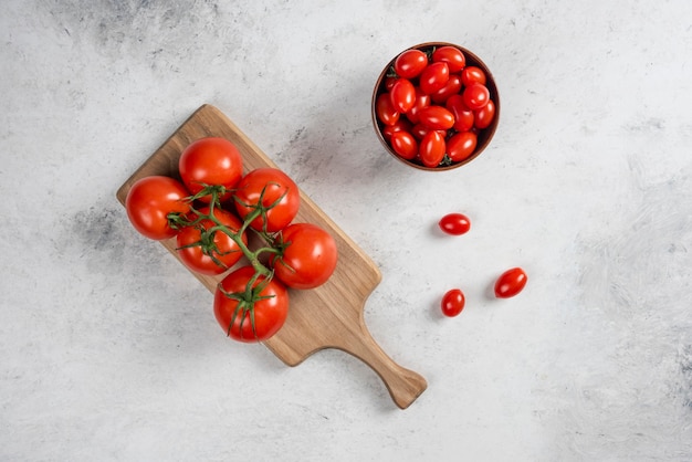 Tomates cherry rojos frescos en un cuenco de madera