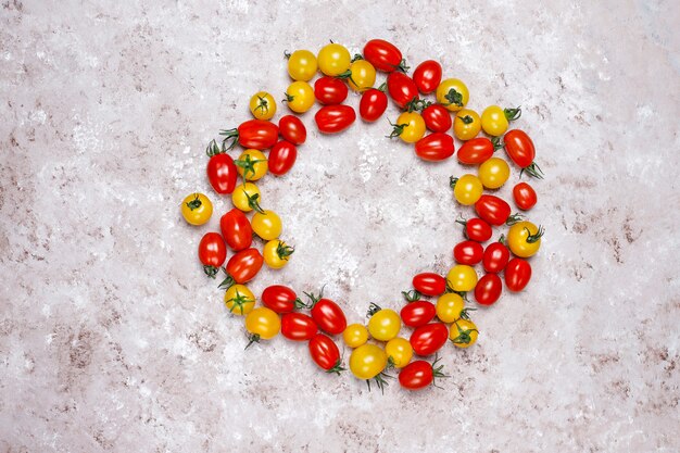 Tomates cherry de varios colores, tomates cherry amarillos y rojos sobre fondo claro