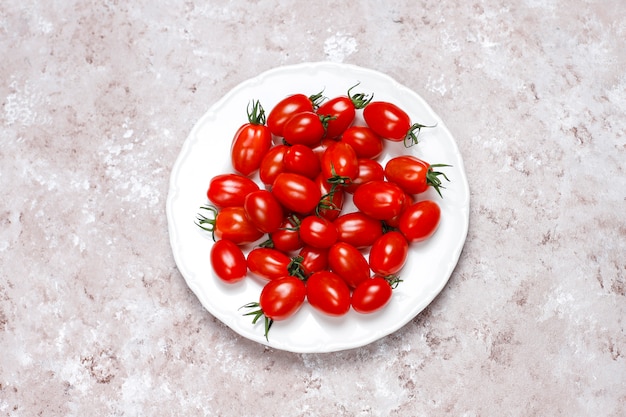 Tomates cherry de varios colores, tomates cherry amarillos y rojos sobre fondo claro