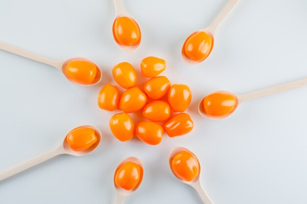 Tomates en cucharas de madera, planos.