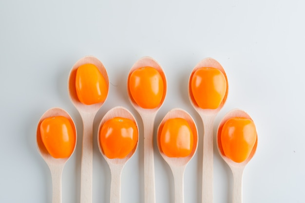 Tomates en cucharas de madera, planos.