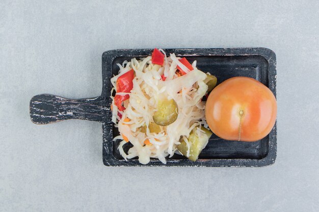 Tomates enteros y chucrut en el tablero