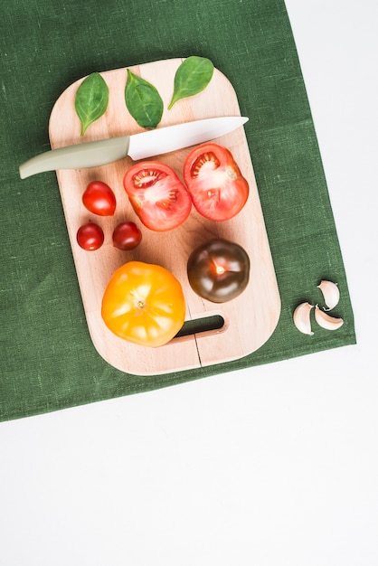 Tomates y espinacas en la tabla de cortar