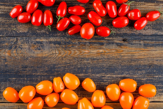 Tomates frescos en la mesa de madera, endecha plana.