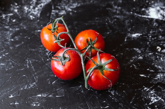 Tomates frescos en la mesa de negro