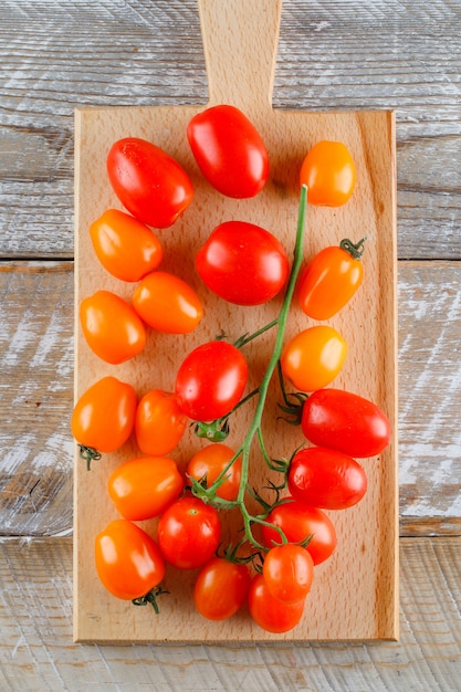 Foto gratuita tomates maduros en madera y tabla de cortar. aplanada