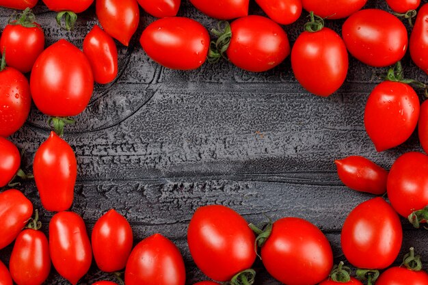 Tomates oblongos en una pared gris grunge.