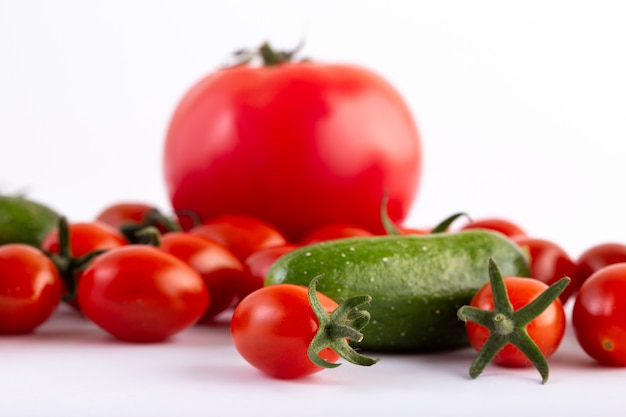 Tomates y pepinos sobre fondo blanco.