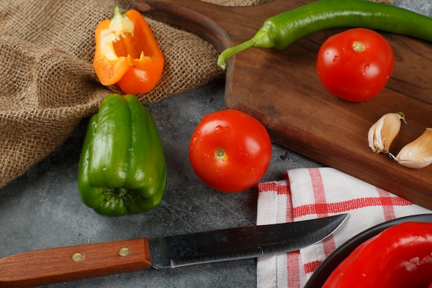 Foto gratuita tomates y pimientos verdes con un cuchillo. vista superior.