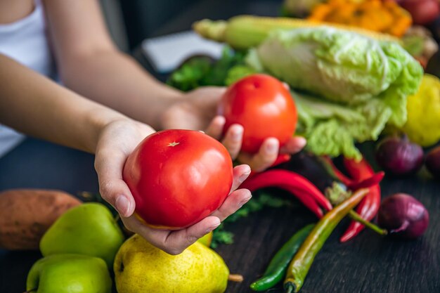 Tomates de primer plano en manos femeninas en la cocina