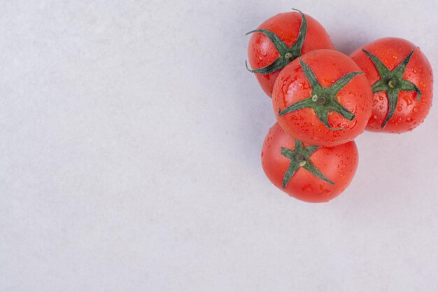 Tomates rojos frescos en el cuadro blanco.