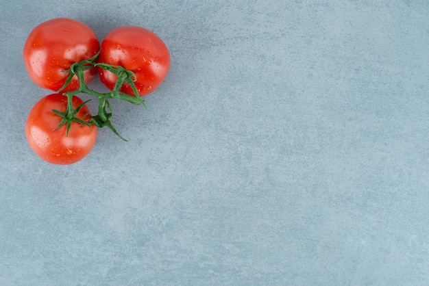 Foto gratuita tomates rojos con gotas de agua en azul.