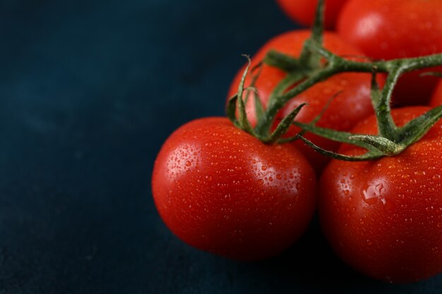 Tomates rojos con gotas de agua sobre ellos.