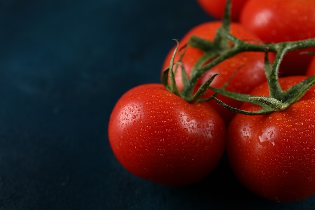 Tomates rojos con gotas de agua sobre ellos.