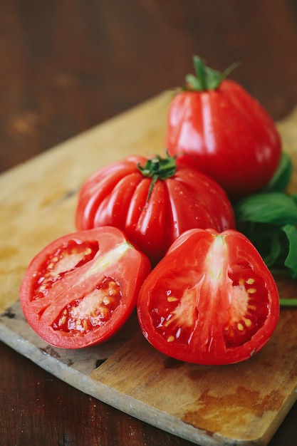 Tomates rojos y hojas de menta sobre una tabla de madera