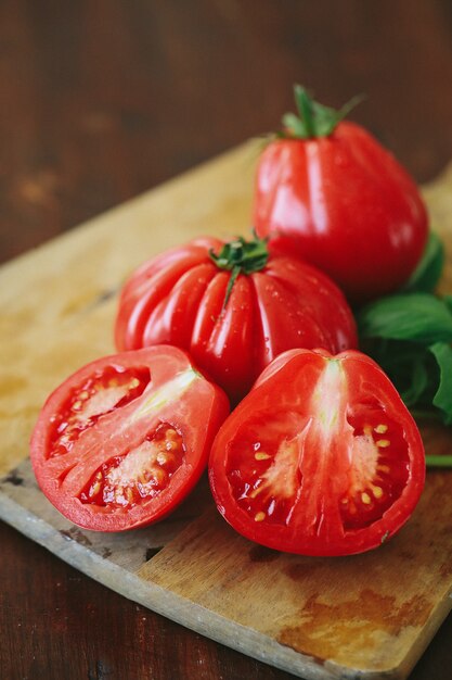 Tomates rojos y hojas de menta sobre una tabla de madera