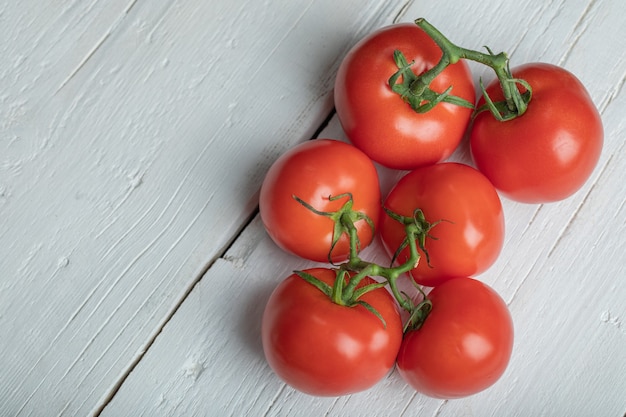 Tomates rojos maduros en mesa de madera