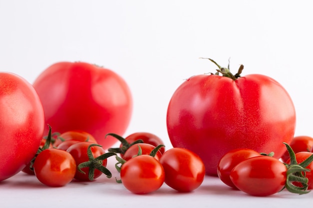 Tomates rojos tomates cherry rojos sobre fondo blanco.