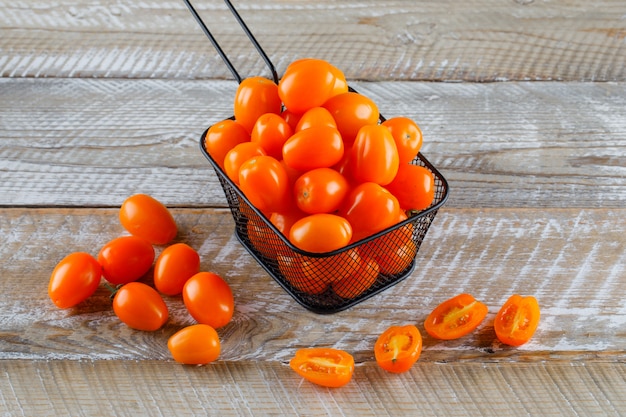 Tomates en una vista de ángulo alto del colador sobre una mesa de madera