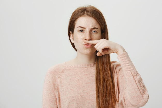 Foto gratuita tonto bastante adolescente haciendo bigote falso con el dedo