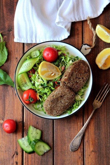 top chuleta de ternera con ensalada de vegetales frescos en un recipiente de metal