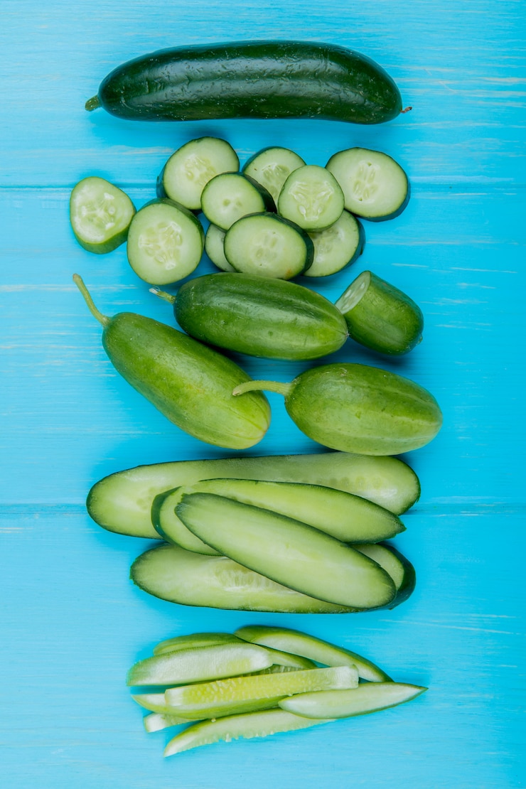Photo Gratis top view of whole cut sliced cucumbers on blue surface
