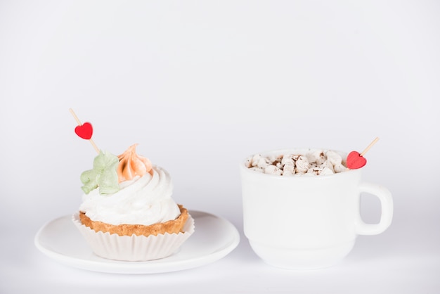 Toppers de corazón en cupcake y taza de café.