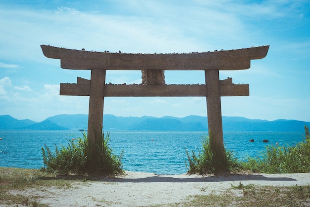 Torii en una playa en la isla de Naoshima bajo la luz del sol en Japón