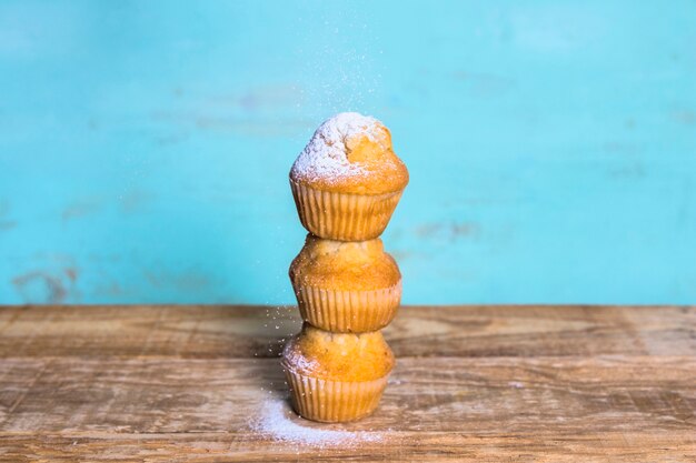 Foto gratuita torre de deliciosos muffins sobre fondo azul