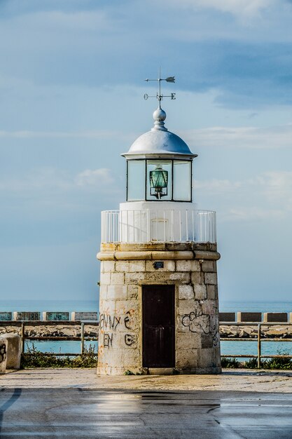 Torre frente al agua bajo un cielo nublado