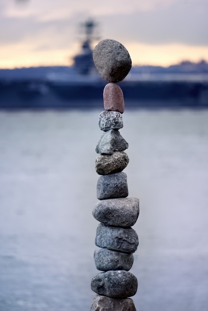 Torre de piedras con un barco como fondo