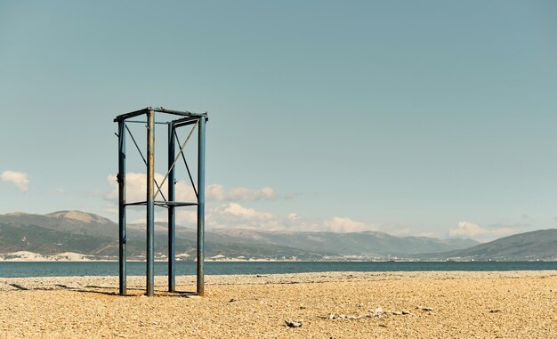 Torre de salvavidas abandonada en una playa de guijarros Costa del Mar Negro playa vacía en un día soleado en abril El cielo se quema al mediodía la bahía del mar en el fondo son las montañas del Cáucaso