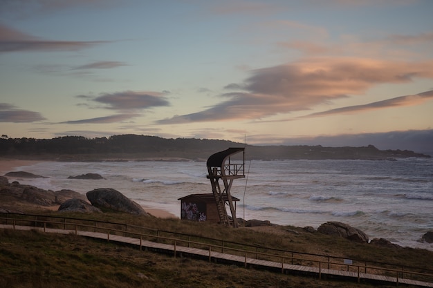 Torre de salvavidas en la playa durante la puesta de sol en el Parque Natural de Corrubedo en España