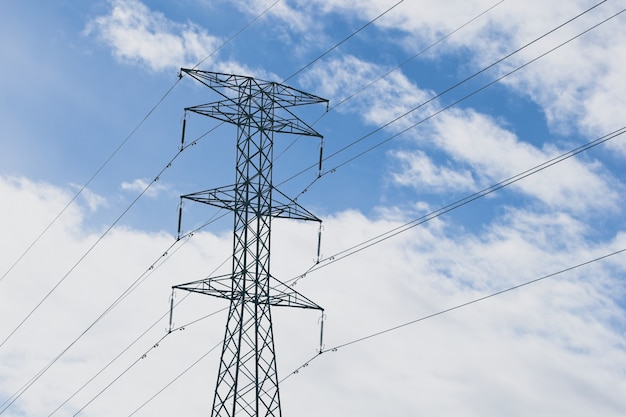 Torres eléctricas con un cielo nublado azul de fondo