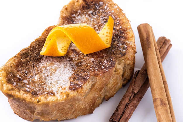 Torrijas caseras tradicionales españolas decoradas con canela y cáscara de naranja aisladas de fondo blanco