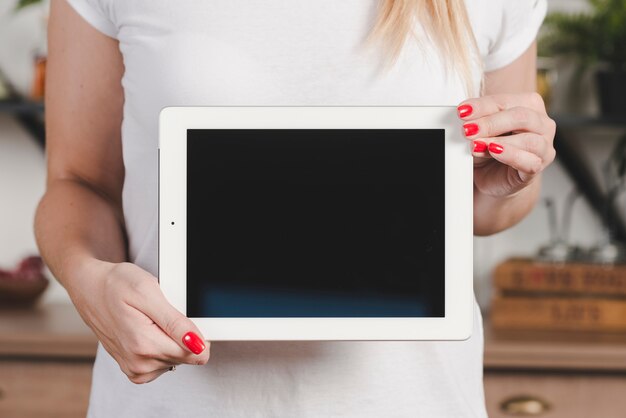 Torso de la mano de la mujer que muestra la pantalla de la tableta digital en blanco